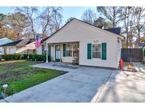 Charming home featuring tidy landscaping, a cozy porch, and a welcoming front yard at 1257 Maryland Dr, Ladson, SC 29456