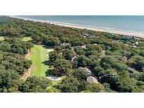 An aerial view features the golf course near a coastal home and the beach at 1365 Dunlin Court, Share C, Kiawah Island, SC 29455