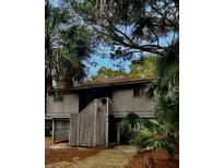 Charming two-story home with a wooden fence and beautiful natural landscaping at 16 Twin Oaks Lane Ln, Isle of Palms, SC 29451
