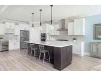 Bright, modern kitchen features stainless steel appliances, a wine fridge, and a large kitchen island with barstool seating at 2094 Cousteau Ct, Johns Island, SC 29455