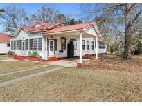 Charming home featuring a metal roof, covered porch, and well-maintained lawn at 222 E Main St, Moncks Corner, SC 29461