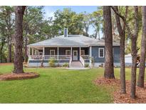 Charming single-story home with a classic porch and beautifully landscaped front yard at 3348 River Landing Rd, Johns Island, SC 29455