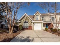 Inviting townhome featuring an attached garage and manicured landscaping in a suburban neighborhood at 5215 Chicory Ln, North Charleston, SC 29420
