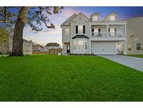 Charming two-story home with landscaped yard, a two-car garage and a lovely second story porch at 1105 Mossy Rock Dr, Summerville, SC 29485