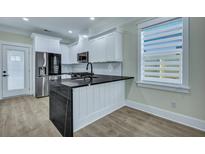 Bright kitchen featuring white cabinets, stainless steel appliances, and a black countertop island at 2035 Beech Ave, North Charleston, SC 29405