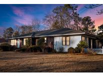 Charming single-story home featuring a mix of brick and siding with a well-manicured lawn and lush landscaping at 209 E 4Th S St, Summerville, SC 29483