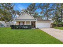 Charming home with a well-manicured lawn, inviting front porch, and attached garage at 2443 Albacore Ave, North Charleston, SC 29406