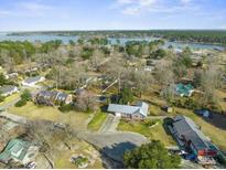 Stunning aerial view of a home with lake access, surrounded by lush greenery and a serene waterfront at 305 Meadowlark Ln, Moncks Corner, SC 29461