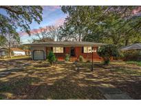 Charming brick home with a well-maintained front yard and mature trees offering shade and curb appeal at 4622 Shawnee St, North Charleston, SC 29405