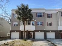 Charming townhome featuring a private garage and a well-maintained, landscaped front yard at 4666 Palm View Cir, North Charleston, SC 29418