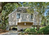 Charming raised home featuring a neutral exterior, lush landscaping, and inviting staircase at 807 Treeloft Trce, Seabrook Island, SC 29455
