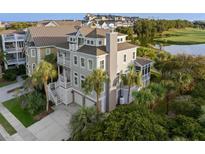 Stunning exterior of a modern home, featuring multi-level balconies, lush landscaping, and a two-car garage at 10 Ocean Point Dr, Isle of Palms, SC 29451