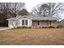 Charming brick home with a covered front porch and well-maintained yard at 1075 Quail Dr, Charleston, SC 29412