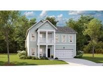 Charming two-story home featuring light green siding, a cozy front porch, and an attached garage at 120 Snow St, Summerville, SC 29486