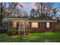 Charming brick home featuring a screened-in porch and well-maintained front yard at 137 Dowling Ave, Walterboro, SC 29488