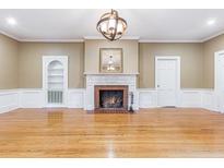 Cozy living room with a beautiful fireplace, hardwood floors, and an elegant light fixture at 1860 Pinopolis Rd, Pinopolis, SC 29469