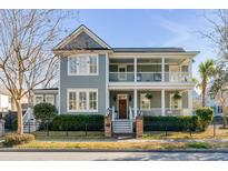 Charming two-story home showcasing a spacious front porch and manicured landscaping at 2 Amelia Ave, Charleston, SC 29403