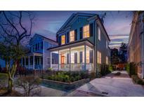 Charming two-story home with a welcoming front porch, landscaped garden, and a secure black iron fence at 3 Bee St, Charleston, SC 29403