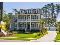 Charming two-story home with a double porch, complemented by a lush, green lawn and an adjacent two-car garage at 3859 Segars Lndg, Mount Pleasant, SC 29466