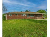 Charming brick home with a well-manicured lawn and covered porch, perfect for enjoying the outdoors at 5322 Dorchester Rd, North Charleston, SC 29418