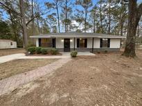 Charming single-story home featuring a brick walkway, updated paint, and a well-maintained front yard at 5863 Octavia Ave, Ravenel, SC 29470