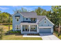 Charming light blue two-story home with a welcoming front porch and well-manicured lawn at 1184 Reserve Ln, Awendaw, SC 29429