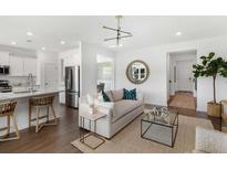 Bright living room featuring modern decor, light hardwood floors, and an open floor plan to the kitchen at 126 East Morton St, Summerville, SC 29486