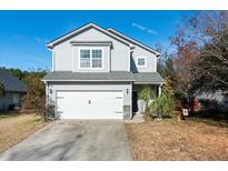 Two-story home with light gray siding, white garage door, and manicured front yard at 243 Clayburne Dr, Goose Creek, SC 29445