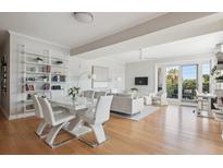 Bright, open living room with modern decor, white furniture, and sliding doors to a balcony at 33 Calhoun St # 218, Charleston, SC 29401
