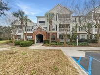 Multi-story condo building with brick entryway, covered balconies, palm trees, and clearly marked handicap parking space at 45 Sycamore Ave # 1413, Charleston, SC 29407