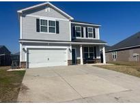 Two-story home with gray siding, a two-car garage, and a well-maintained lawn and long concrete driveway at 619 Ravens Wood Rd, Summerville, SC 29486