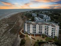 Beautiful sunset aerial view of beachfront condos with beach access and community pool at 8000 Palmetto Dr # 103-A, Isle of Palms, SC 29451