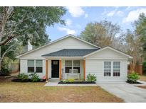 Charming single-story home with a welcoming front porch and well-manicured landscaping at 115 Ridge Rd, Summerville, SC 29485