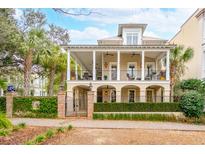 Stately two-story home with a double porch, landscaped yard, and mature palm trees at 121 W Shipyard Rd, Mount Pleasant, SC 29464