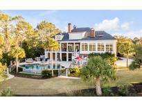 Luxury home showcasing pool, manicured lawn, and outdoor living area with stunning architectural design at 1444 Madison Ct, Mount Pleasant, SC 29466