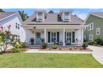Charming single-Gathering home with a welcoming front porch, well-maintained lawn, and beautiful landscaping at 1710 Sparkleberry Ln, Johns Island, SC 29455