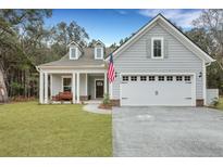 Charming single-Gathering home featuring a two-car garage and a welcoming front porch with an American flag at 4263 Hugh Bennett Dr, Johns Island, SC 29455