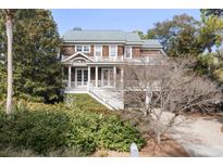 Stunning home featuring a welcoming porch, beautiful wood finishes, and lush landscaping at 707 Glossy Ibis Ln, Kiawah Island, SC 29455