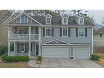 Charming two-story home featuring a front porch, balcony, dormer windows, and a spacious three-car garage at 7217 Mossy Creek Ln, Hanahan, SC 29410