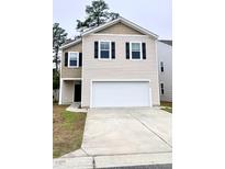 Charming two-story home features neutral siding, a two-car garage, and tidy landscaping at 9724 Roseberry St, Ladson, SC 29456