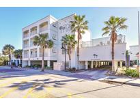 A lovely hotel exterior showcasing multiple balconies and palm trees at 1126 Ocean Blvd # 109, Isle of Palms, SC 29451