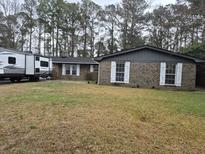 Charming brick home with a well-maintained lawn and mature trees providing shade and curb appeal at 113 Ford Ct, Summerville, SC 29483