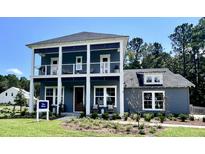 Inviting two-story home with a beautiful, covered double porch and professionally landscaped front yard at 1168 Reserve Ln, Awendaw, SC 29429