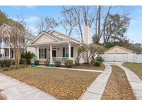 Charming one story home featuring a welcoming front porch, a driveway, and a detached garage at 1435 Swamp Fox Ln, Charleston, SC 29412
