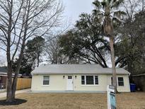 Charming single-story home featuring a metal roof, complemented by mature trees and an inviting front lawn at 1508 Greenbay Dr, North Charleston, SC 29406