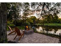 Beautiful backyard patio with cozy fire pit and tranquil water view for evening relaxation at 1756 Indigo Island Dr, Hanahan, SC 29410