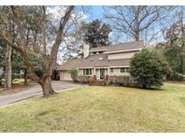 Charming home featuring a manicured lawn, mature trees, and inviting front entrance at 2 Pony Ln, Charleston, SC 29407