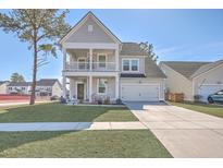 Charming home featuring a double porch, manicured lawn, and a classic gray and white color scheme at 203 Red Bluff St, Summerville, SC 29483