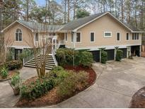 Spacious home with a three-car garage, beautiful landscaping, and an inviting staircase to the front entry at 2595 Bohicket Rd, Johns Island, SC 29455