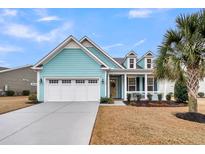 Charming home featuring a three-car garage, dormer windows, teal siding, and a well-manicured front yard at 3115 Cross Vine Ln, Summerville, SC 29483